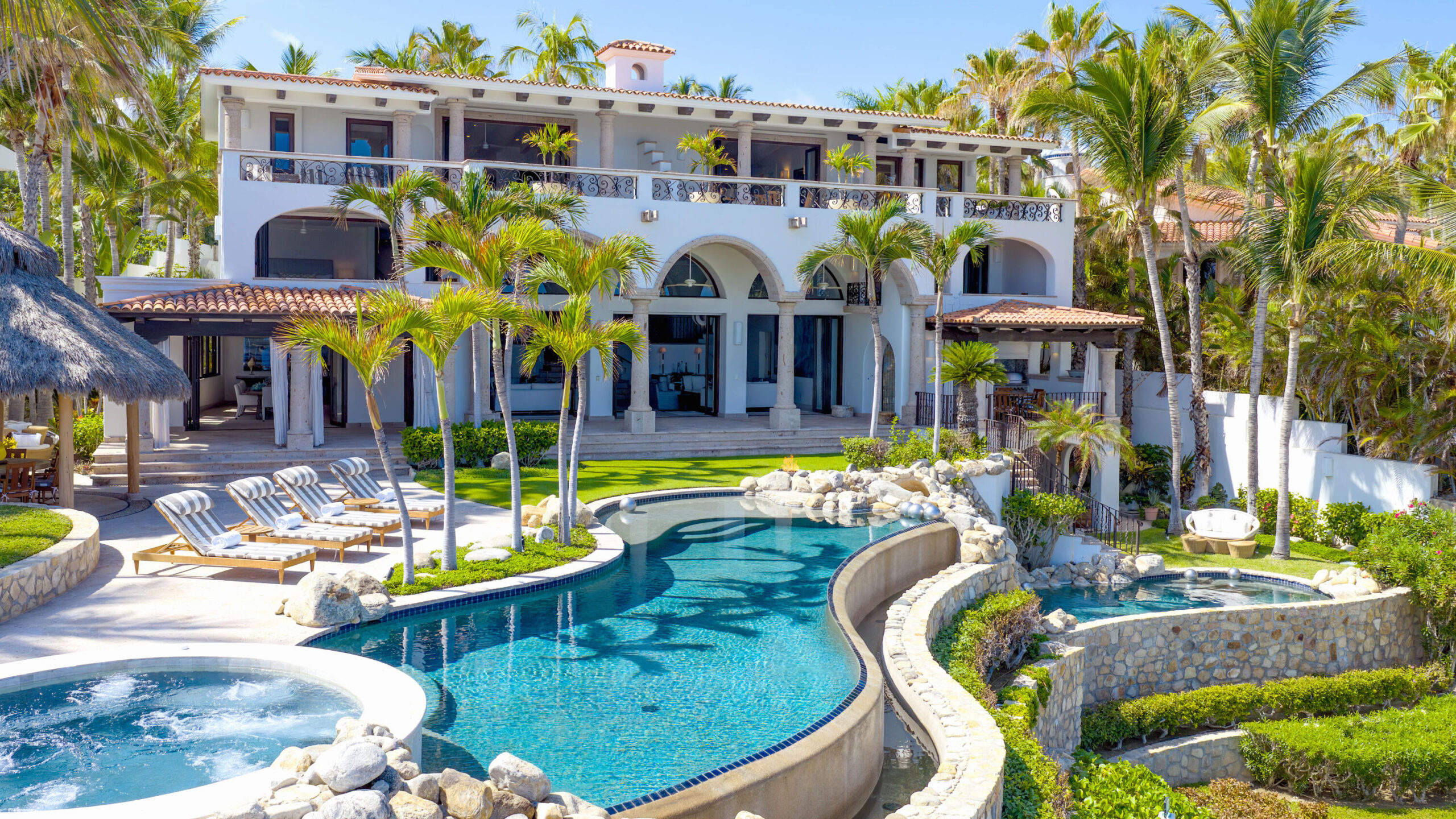 Palmilla La Caleta A once-in-a-generation legacy estate, never before on the market, this iconic beachfront residence offers incomparable prestige on the sands of Palmilla Bay, one of Cabo's most coveted and swimmable beaches. Set on a rare half-acre parcel directly on the water, the home features six bedrooms, six and a half baths, plus a full attached apartment, all executed in classic Palmilla style with timeless elegance and modern comfort. From the moment you enter, the architecture reveals its intention: a grand foyer flows effortlessly into an open living area and bar, framed by soaring ceilings and vast windows that disappear into the Baja breeze. The interiors dissolve into the outdoors, unveiling a dramatic terrace that cascades to a manicured lawn, infinity-edged pool, waterslide, spa, and expansive entertaining pavilion designed for unforgettable gatherings beneath the stars.The second level hosts two principal suites, each opening to a vast private terrace with sweeping – Casa R Caleta Palmilla, San Jose Corridor, BS